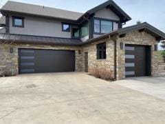 Stone edged home with a dark contrasting garage door