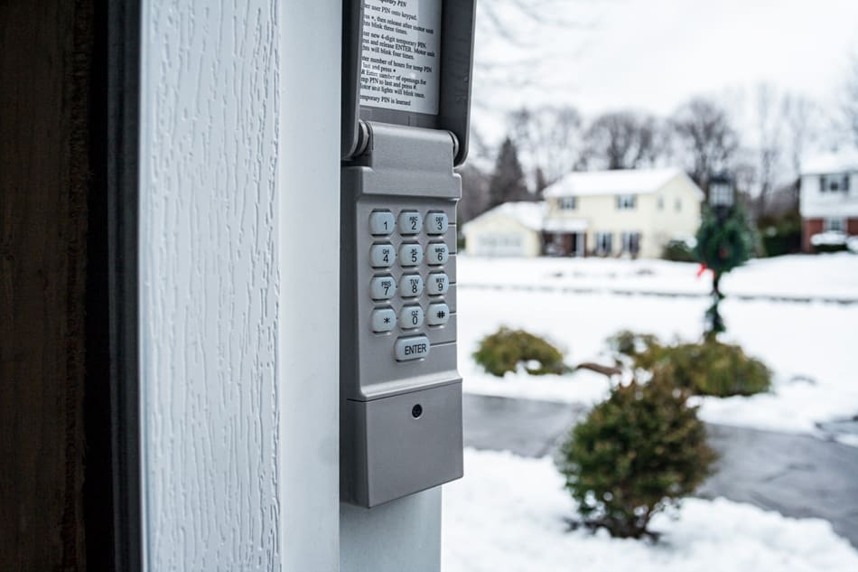 Automatic garage door opener security code keypad attached on the outside of a suburban residential district private home two car garage door frame.